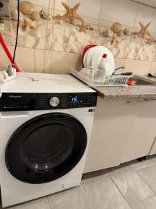 a kitchen with a washing machine and a sink at Turda central apartament in Turda +16 photos