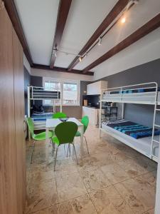 a room with a table and chairs and bunk beds at Boardinghouse Wildbachtal in Boxtal