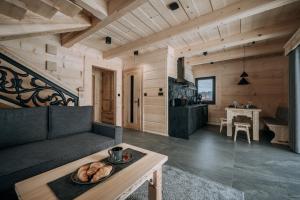 a living room with a table with a bowl of bread on it at Tatrowisko Zakopane Domki Góralskie in Zakopane