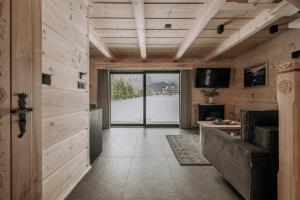 a hallway with wooden walls and a large glass door at Tatrowisko Zakopane Domki Góralskie in Zakopane