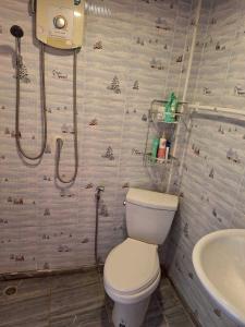 a bathroom with a toilet and a sink at Meesaeng Homestay in Thalang