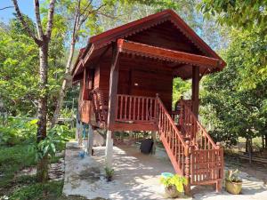 a small wooden house with a staircase leading to it at Meesaeng Homestay in Thalang