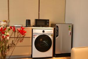 a kitchen with a washing machine and a refrigerator at Migoo Chiang Mai in Chiang Mai