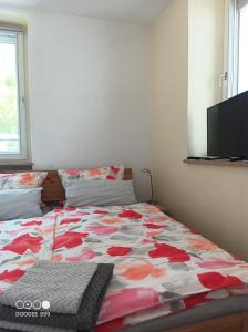a bedroom with a bed with a floral comforter at Gästehaus am Main in Randersacker
