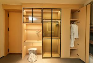 a walk in closet with glass doors and a stool at Migoo Chiang Mai in Chiang Mai