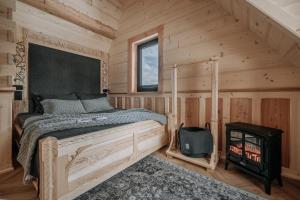 a bedroom with a bed and a wood stove at Tatrowisko Zakopane Domki Góralskie in Zakopane