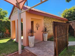 a small house with a gate and potted plants at Lafenis Selfsorg in Jan Kempdorp