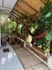 a porch with benches and a hammock under a roof at In Home stay in Bulakbenda