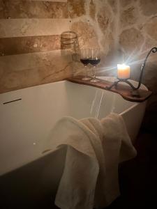 a candle and two glasses of wine in a bath tub at Casa Picătura de Rouă in Beliş +47 photos