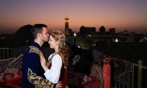 a man and a woman standing on top of a building at NANOSH EAST HOTEL in Bukhara