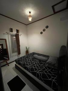a bedroom with a bed with a black and white comforter at In Home stay in Bulakbenda