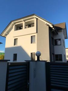 a white house with a gate and a fence at Bright & Cozy Apartment in Villach