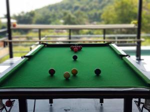 a green felt pool table with balls on it at Pool&chill kohlarn in Ko Larn +3 photos