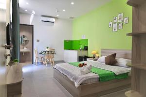a bedroom with a bed with a green wall at Minimalhaven Stay in Vung Tau