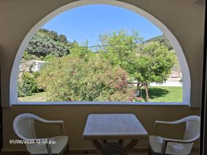an arched window with a table and two chairs at Santa Maria in Vitalades