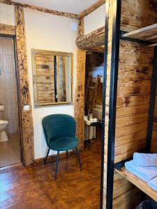 a room with a green chair and a bunk bed at Hanul Bărăției in Câmpulung