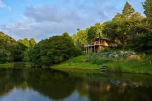 a house on the side of a river with a house at AfriCamps Magoebaskloof in Magoebaskloof