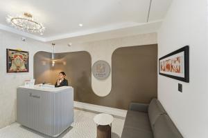 eine Frau steht an einem Rezeptionstresen in einem Zimmer in der Unterkunft Hotel A Square Rivera in Salem