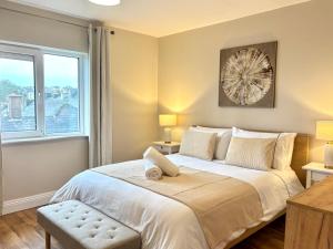 a bedroom with a large bed and a window at Cobh Coastline Hideaway in Cobh