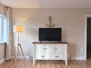 a white dresser with a television on top of it at Cobh Coastline Hideaway in Cobh