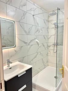 a bathroom with a sink and a glass shower at Cobh Coastline Hideaway in Cobh