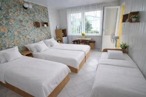 a hotel room with three beds and a window at Nella - Pokoje gościnne in Ostrowo