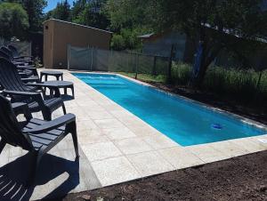 a swimming pool with lounge chairs next to it at Cabañas Del Lolo in Villa Ventana