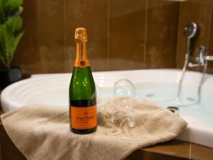 a bottle of wine sitting on a towel next to a bath tub at Villa Alaya in Kos