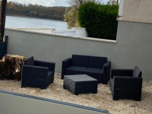 four wicker chairs and a table on a patio at Maison Les Cygnes face au lac in Changey