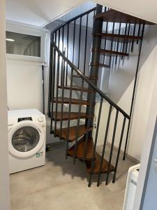 a staircase in a laundry room with a washing machine at Maison Les Cygnes face au lac in Changey