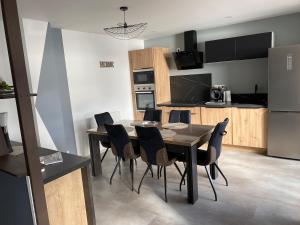 a kitchen and dining room with a table and chairs at Maison Les Cygnes face au lac in Changey