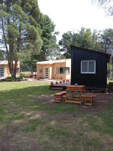 a house with a picnic table in front of it at Cabañas Del Lolo in Villa Ventana