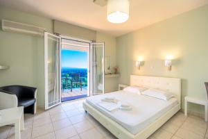 a bedroom with a large bed and a balcony at Ionian Balcony Hotel Apartments in Khavdháta +51 photos