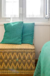 two green pillows sitting on top of a couch at Casa da Estefânea in Sintra