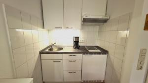 a small kitchen with a sink and a counter top at Terrassenhaus, FeWo 32 in Duhnen
