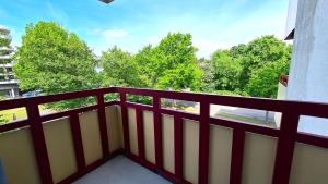 a balcony with a red and white railing and trees at Terrassenhaus, FeWo 32 in Duhnen