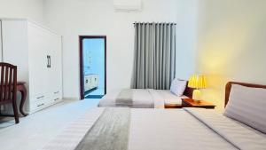 a bedroom with two beds and a dresser with a lamp at Spacious Siem Reap Sanctuary in Phumi Ta Phul +44 photos