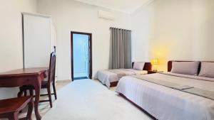 a bedroom with two beds and a desk and a piano at Spacious Siem Reap Sanctuary in Phumi Ta Phul