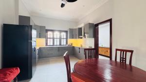 a kitchen with a wooden table and a dining room at Spacious Siem Reap Sanctuary in Phumi Ta Phul
