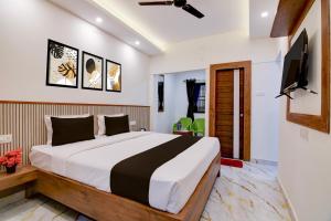 a bedroom with a bed and a flat screen tv at Super Hotel O Vitali Suites in Bhubaneshwar