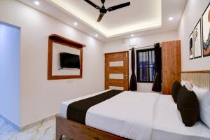 a bedroom with a large bed and a mirror at Super Hotel O Vitali Suites in Bhubaneshwar