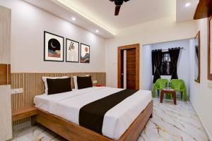 a bedroom with a large bed and green chairs at Super Hotel O Vitali Suites in Bhubaneshwar +28 photos