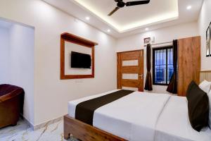 a bedroom with a bed and a tv on the wall at Super Hotel O Vitali Suites in Bhubaneshwar