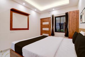 a bedroom with a white bed and a window at Super Hotel O Vitali Suites in Bhubaneshwar