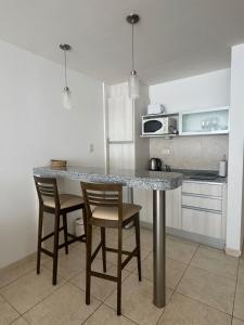 a kitchen with a table and chairs in a kitchen at Puerto Amarras II 01 in Santa Fe