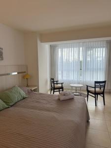 a bedroom with a large bed with chairs and a table at Puerto Amarras II 01 in Santa Fe