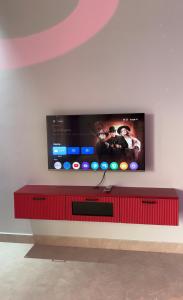 a flat screen tv on a white wall at Teddy in Malpe