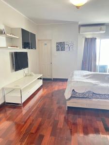 a bedroom with a bed and a desk in it at Supalai Park Srinakarin Penthouse in Ban Nong Chaeng