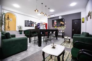 a living room with green furniture and a piano at kutaisi hostel hub in Kutaisi