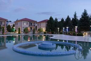 a swimming pool in the middle of a building with lights at Ramada Plaza by Wyndham Gence in Ganja